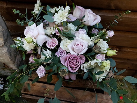 A bridal bouquet of roses in pale shades of lilac and light purples