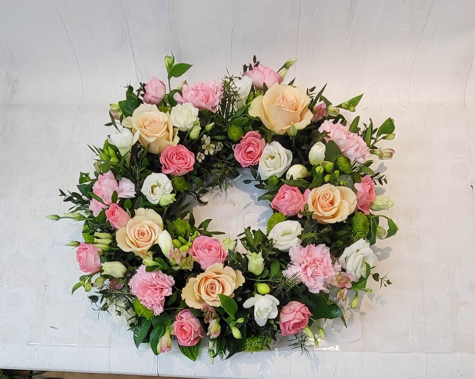 Pretty Pastel Wreath with Roses Funeral Arrangement